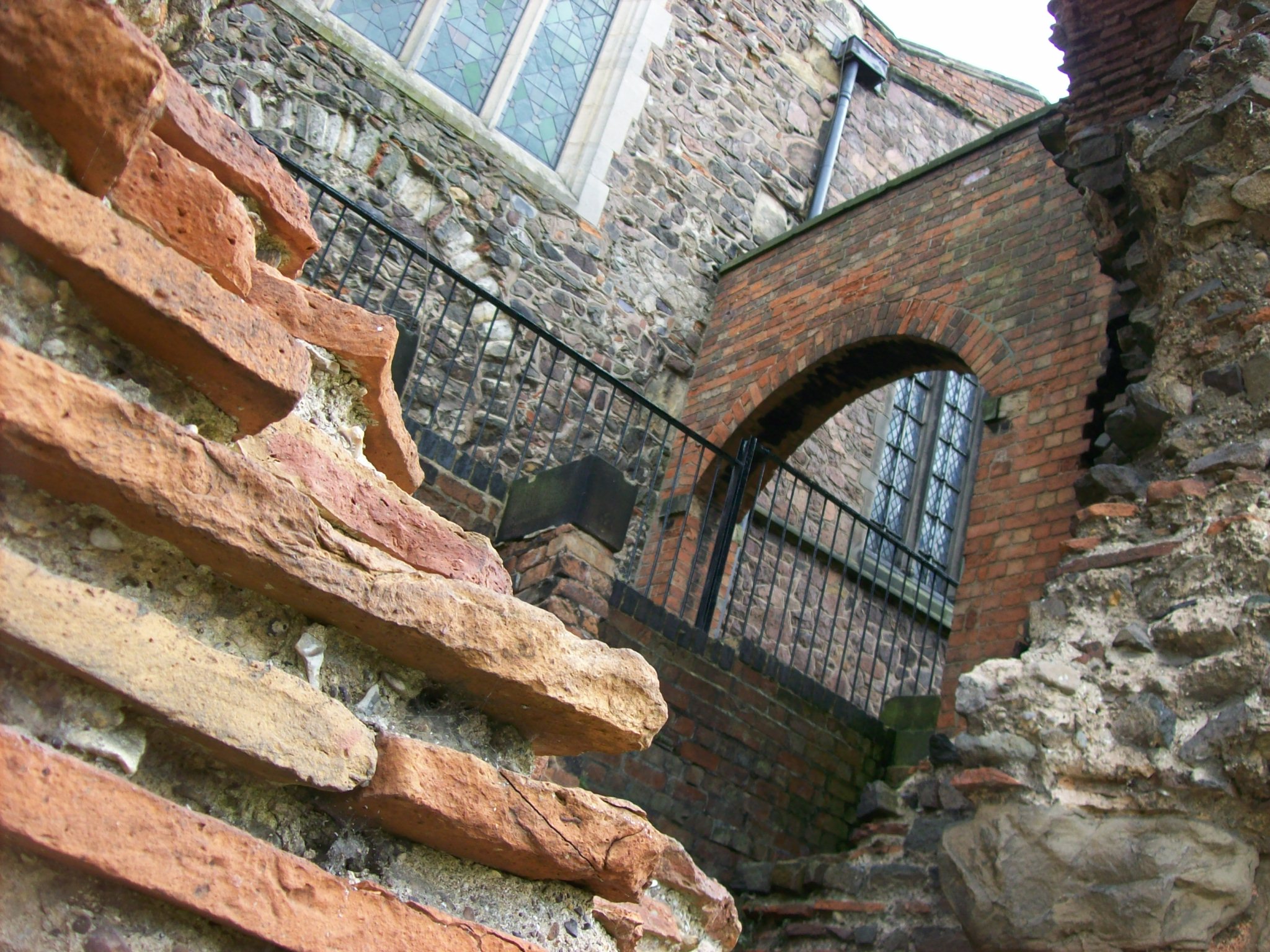 A Roman brick wall or archway incorporated into a much later building, perhaps a medieval church or a Renaissance palazzo.